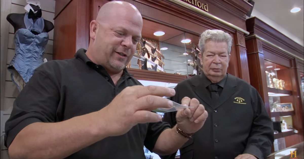 Screenshot showing Rick Harrison and his father looking at the shred of the rare $20 bill (Cover image source: YouTube/Pawn Stars)