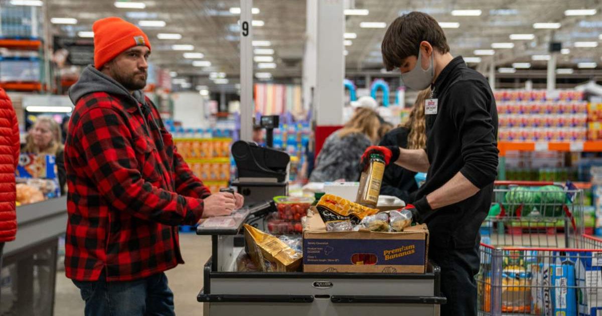 A customer moves through the checkout lane with his groceries at a Costco | Getty Images | Robert Nickelsberg)