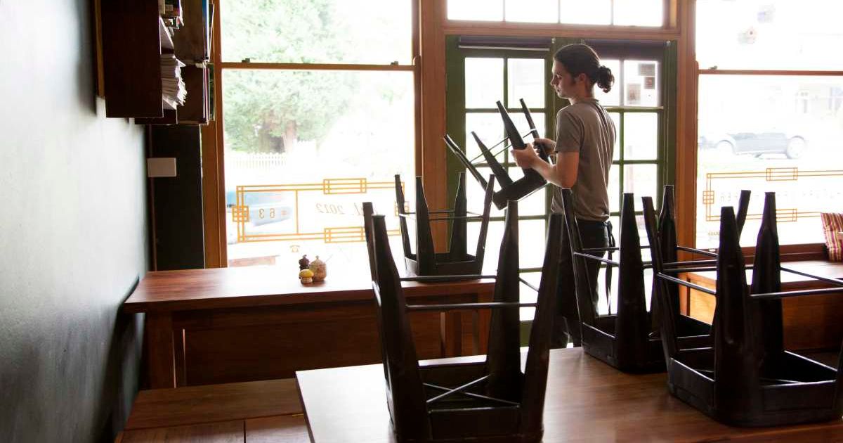 Representative image showing a waiter packing up cafe or restaurant chairs (Image source: Getty Images/Stock photo by The Photo Commune)
