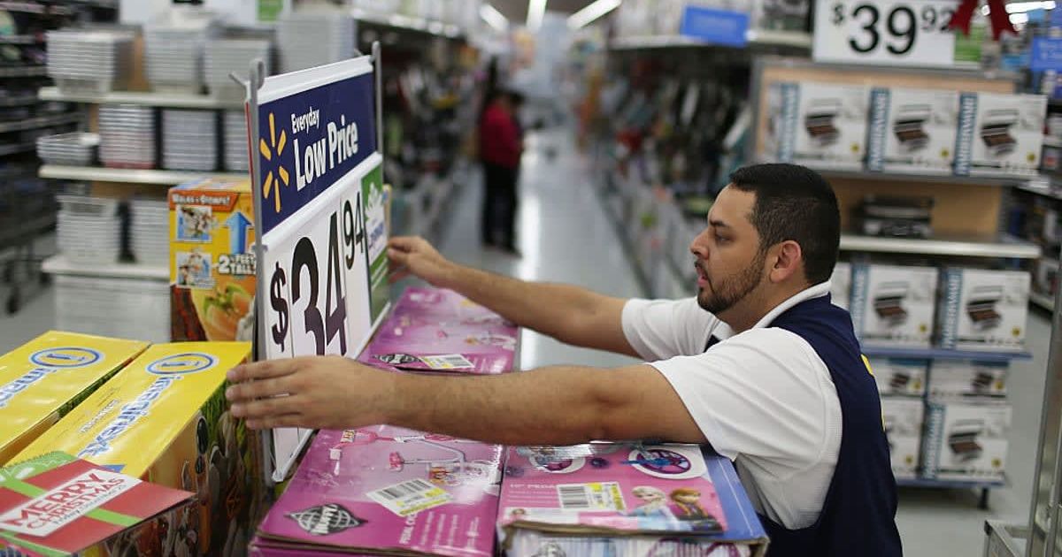 Representative Image of an employee fixing a display in the aisle at a Walmart store (Cover image source: Getty Images | Photo by Joe Raedle)