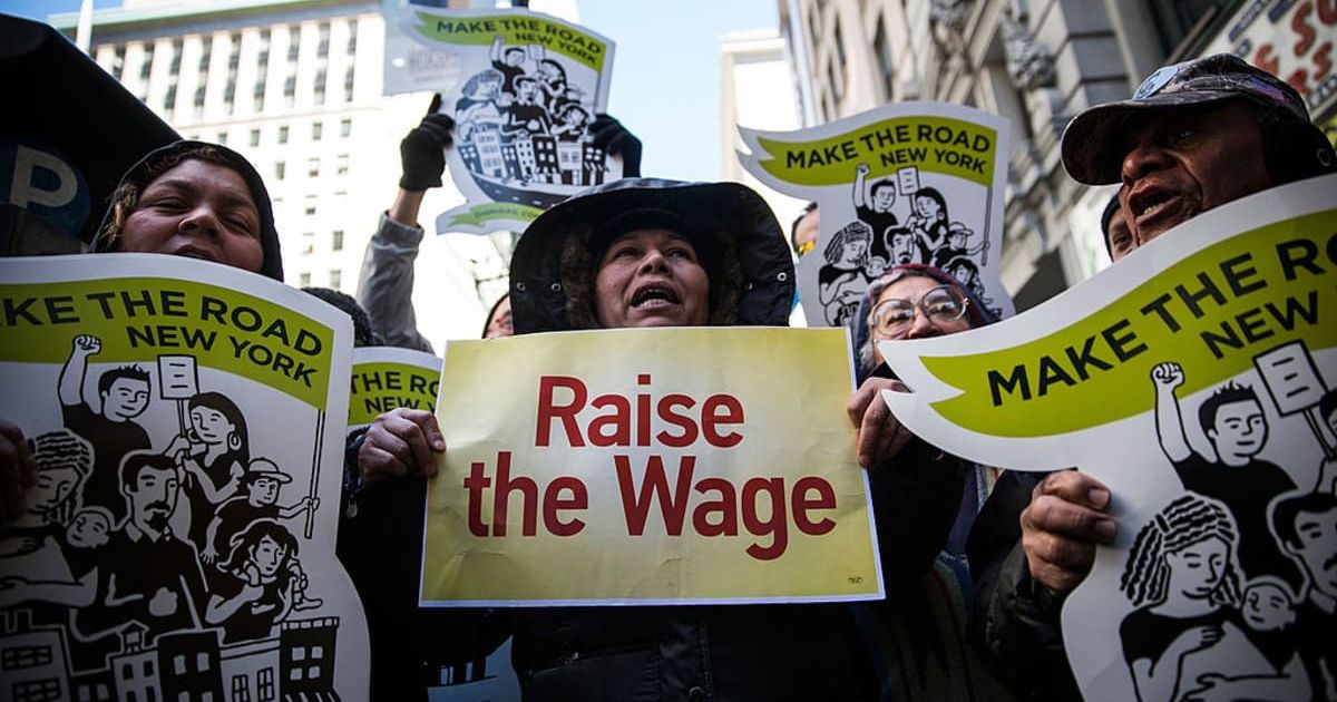 Women hold banners during a protest for higher wages for fast food workers | Getty Images | Photo by Andrew Burton