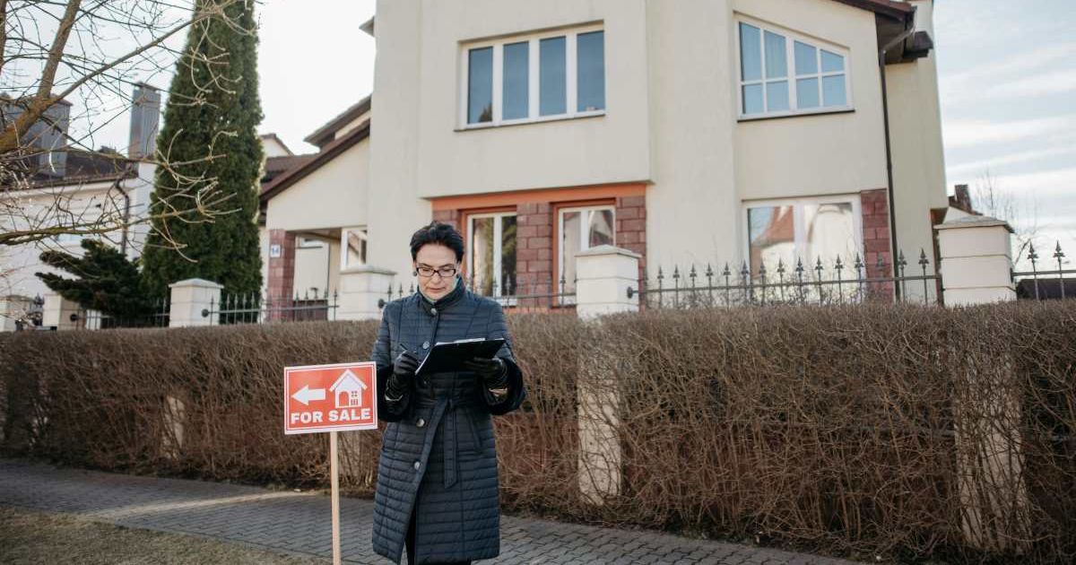 An estate agent in front of a house for sale (Cover image source: Pexels)