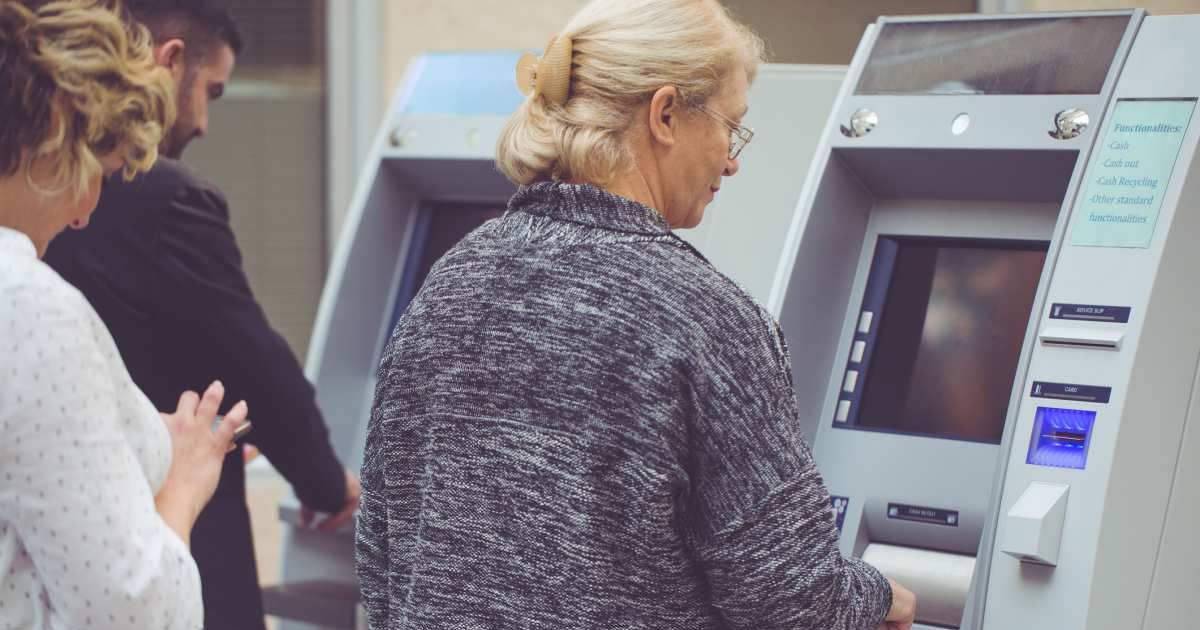 A woman checking her balance at an ATM (Cover Image Source: Getty Images| Photo by Zoranm) 