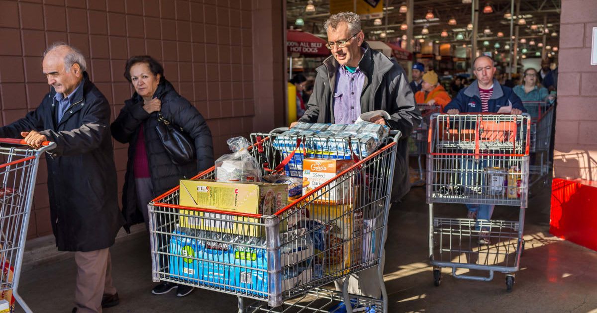 People with shopping carts filled with groceries walking out of a Costco store in Virginia (Cover Image Source: Getty Images | Photo by krblokhin)
