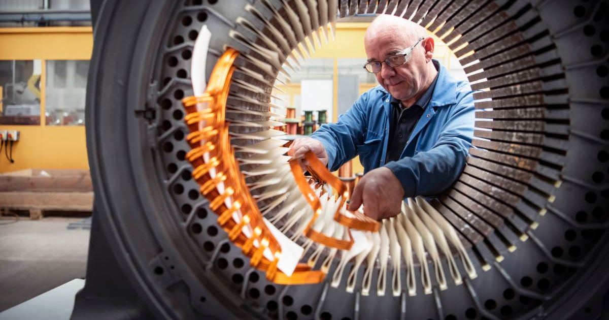 Representative image of an electrical engineer installing copper windings into generator stator (Cover image source: Getty Images/Photo by Monty Rakusen)