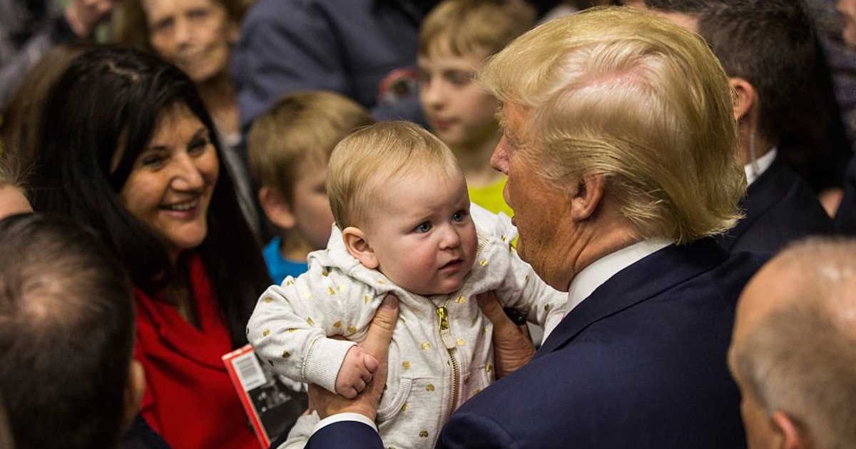 President Donald Trump with a child (Cover Image Source: Getty Images| Photo by Andrew Burton) 
