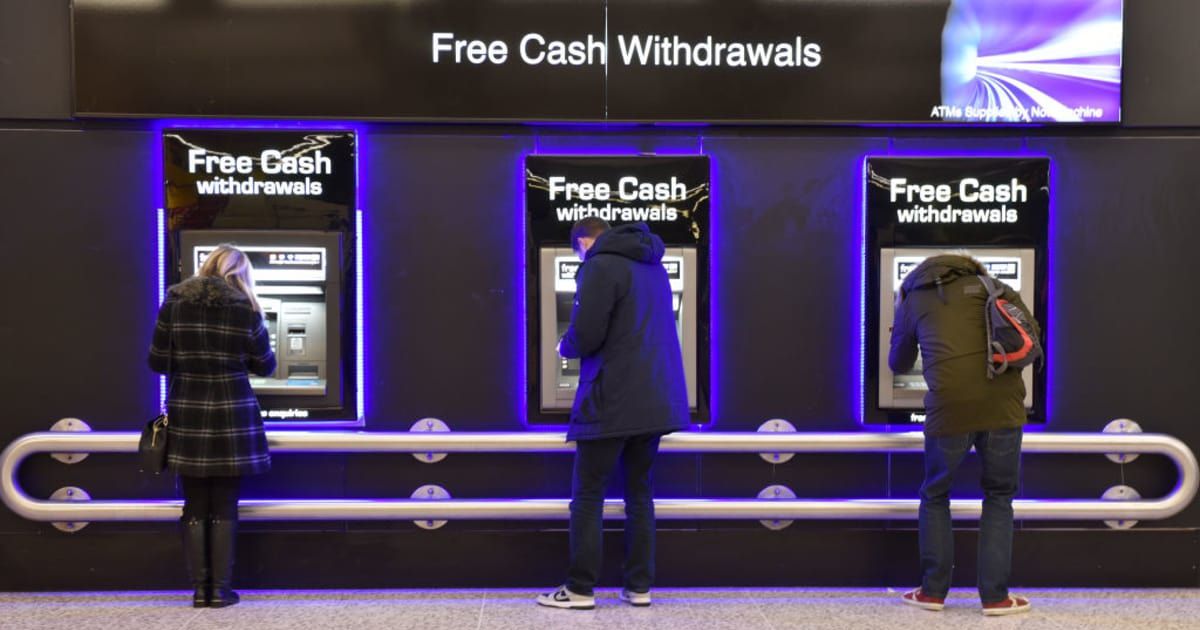 People withdraw cash from free ATM cash machines (Cover image source: Getty images | John Keeble)