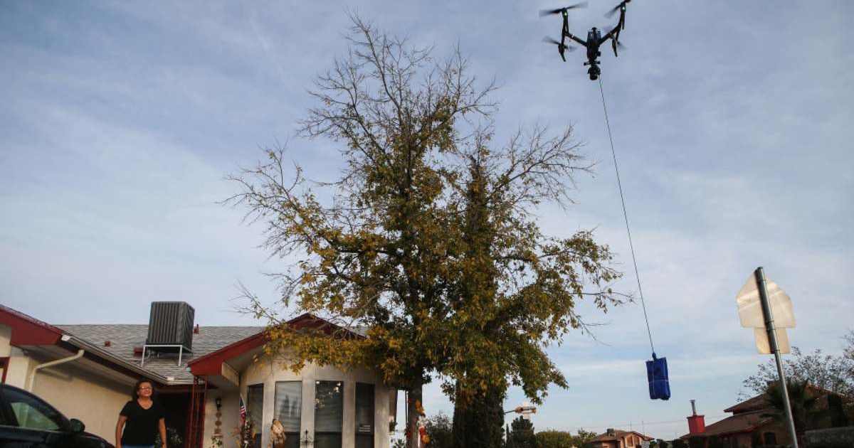 Representative image of a resident watching a drone delivering a COVID-19 self collection test kit from a Walmart Supercenter (Cover image source: Getty Images/Photo by Mario Tama)