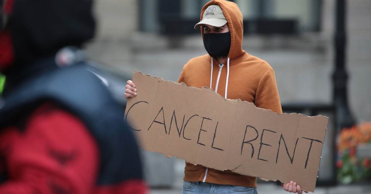 Representative cover image of a demonstrator calling to suspend rent and mortgage payments (Cover image source: Getty Images | Photo by Scott Olson)
