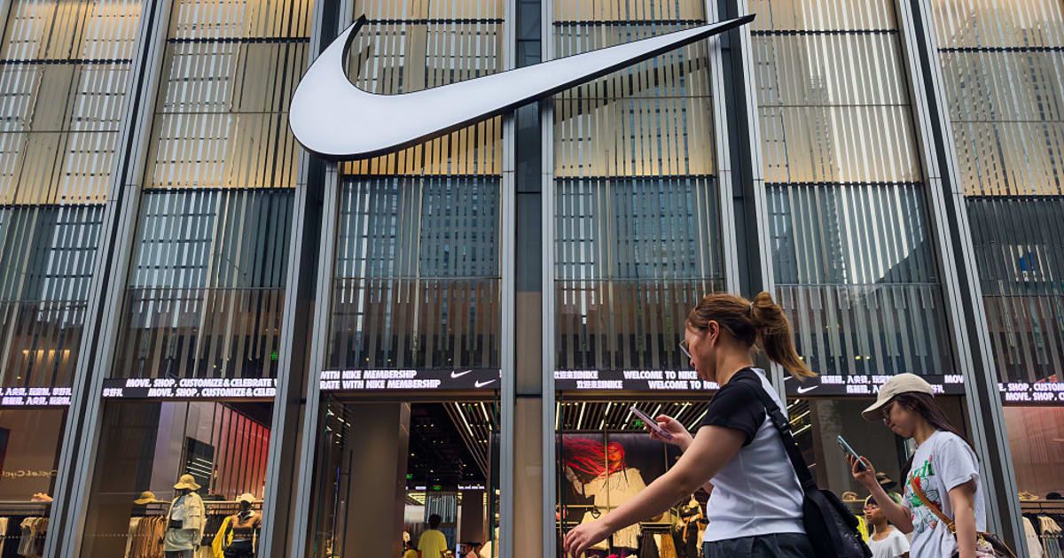 Pedestrians walking past a Nike store (Cover Image Source: Getty Images | Photo by Cheng Xin) 
