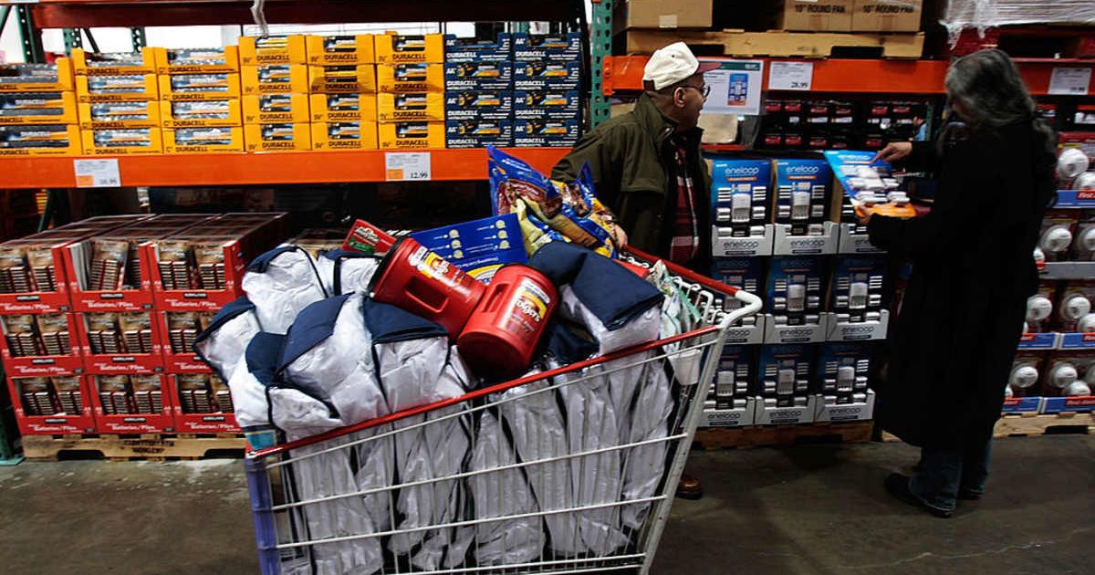 Shoppers stand near a filled cart in a store | (Cover Image Source: Getty Images | Chris Hondros)