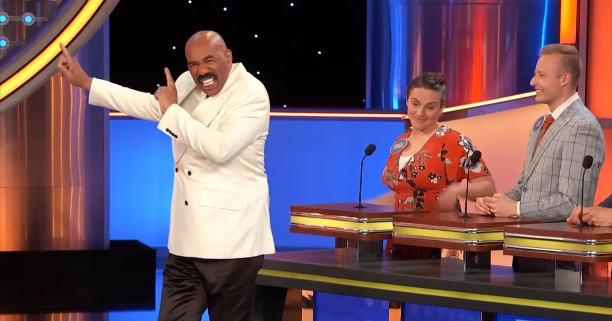 Screenshot showing Harvey pointing to the board (Cover image source: YouTube/Family Feud)