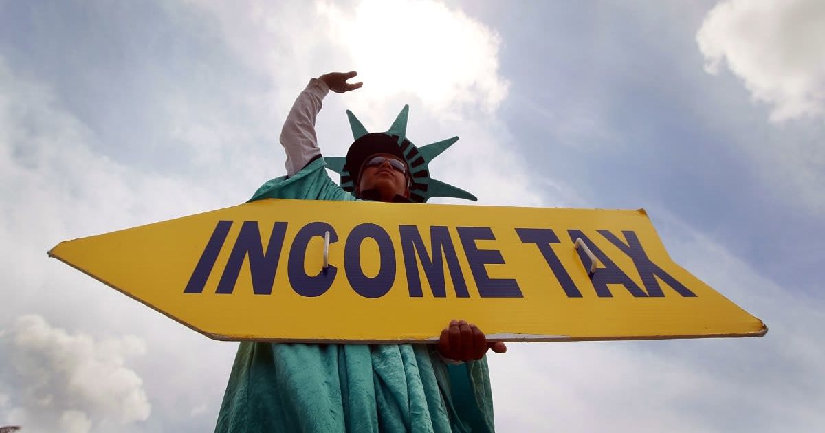  Felipe Castro holds a sign advertising a tax preparation office for people who still need help completing their taxes (Cover image source: Getty Images | Photo by Joe Raedle)