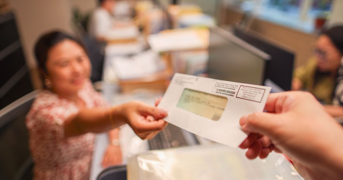 Representative image of a person receiving a check (Cover Image Source: Getty Images| Photo by bernie_photo) 