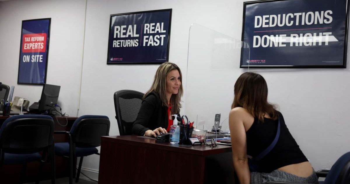 A woman talking to a tax preparation specialist. (Representative Cover Image Source: Getty Images | Joe Raedle)
