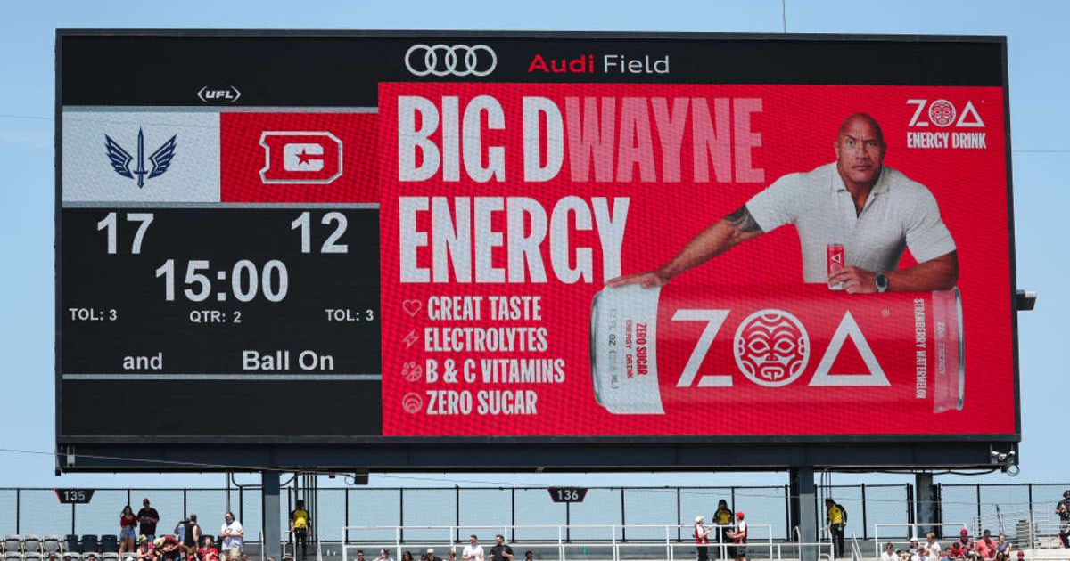 A general view of an advertisement for ZOA Energy Drink with Dwayne Johnson on a scoreboard (Cover image source: Getty Images/Photo by Scott Taetsch/UFL)