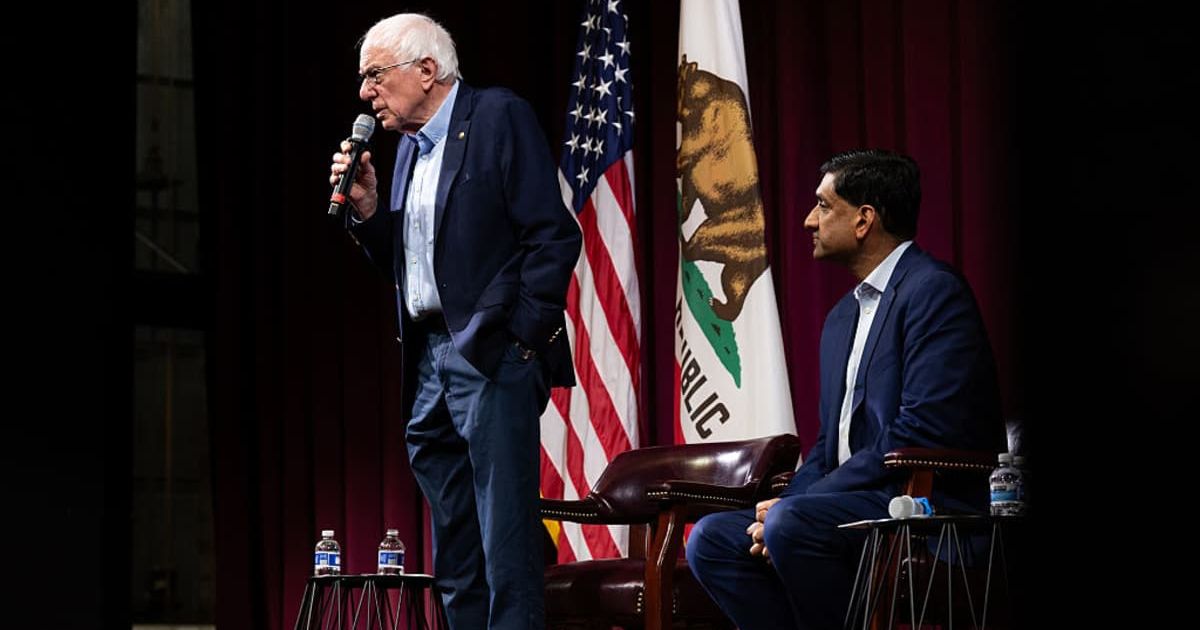  Sen. Bernie Sanders (I-VT) speaks next to Rep. Ro Khanna (D-CA) at a town hall event on February 20, 2026 in Stanford, California (Cover image source: Getty Images/Photo by Benjamin Fanjoy)