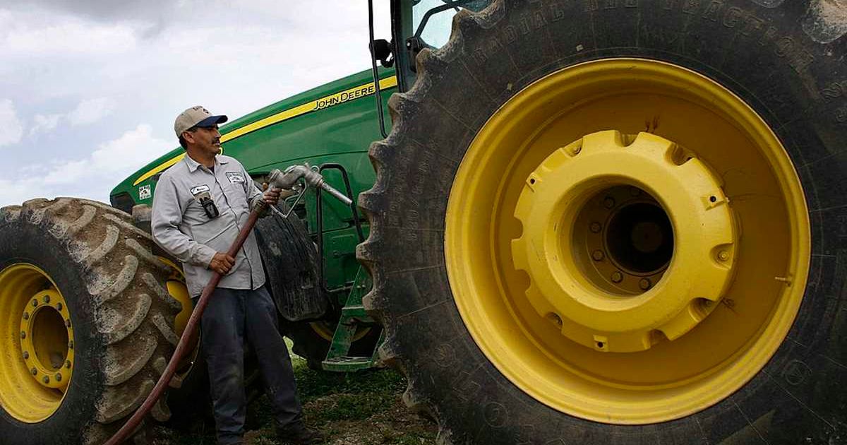 Representative image of a farmer, Martin Valle fuelling a tractor (Cover image source: Photo by Joe Raedle)