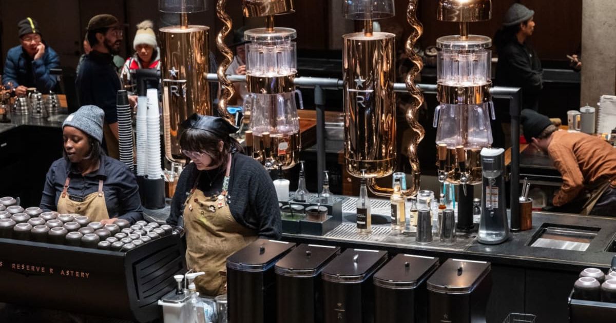 (Image Source: People work at a Starbucks in Manhattan| Photo by Spencer Platt | Getty Images)